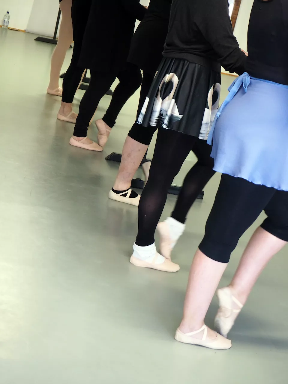 Dancers at the barre in ballet slippers